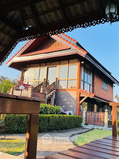 Charming traditional wooden house with intricate details and lush garden, perfect for serene living.