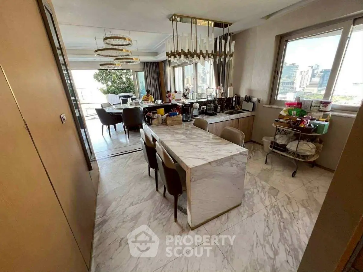 Luxurious open-plan kitchen and dining area with marble flooring and city view.