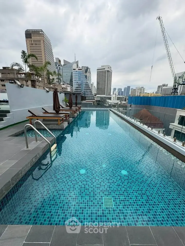 Luxurious rooftop pool with stunning city skyline views in a modern urban setting.