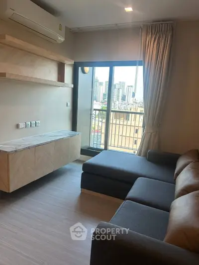 Modern living room with city view, featuring sleek furniture and large windows for natural light.