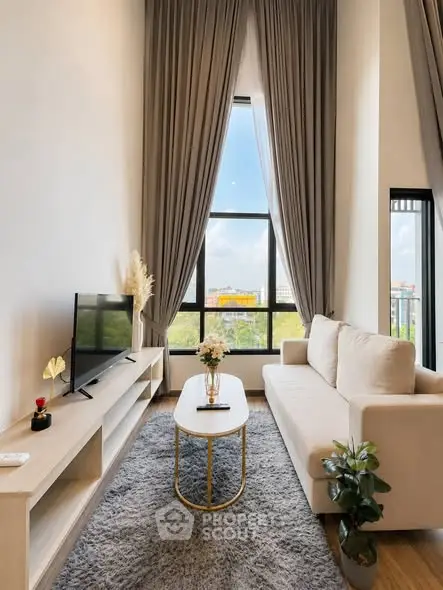 Modern living room with high ceilings, large window, and elegant decor