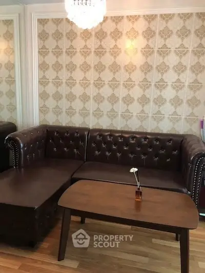 Elegant living room with classic leather sofa and wooden coffee table, perfect for cozy gatherings.