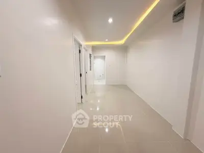 Spacious modern hallway with glossy tiled flooring and ambient lighting