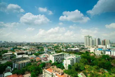 Stunning cityscape view with lush greenery and modern buildings under a clear blue sky.