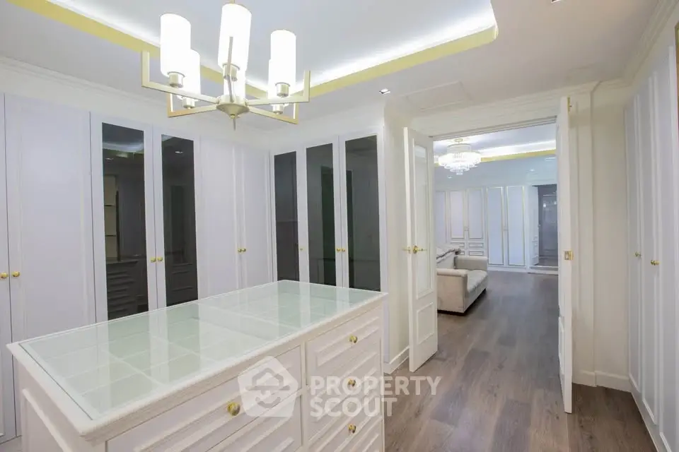 Luxurious walk-in closet with elegant lighting and ample storage space