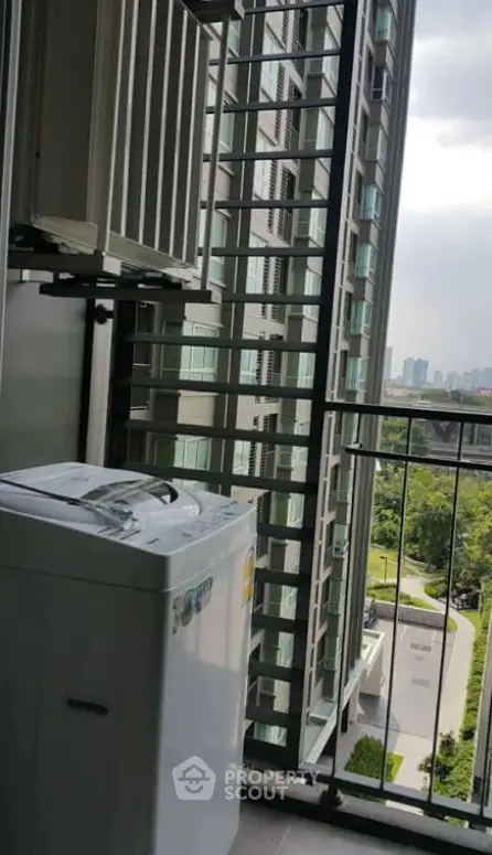 High-rise apartment balcony with washing machine and city view
