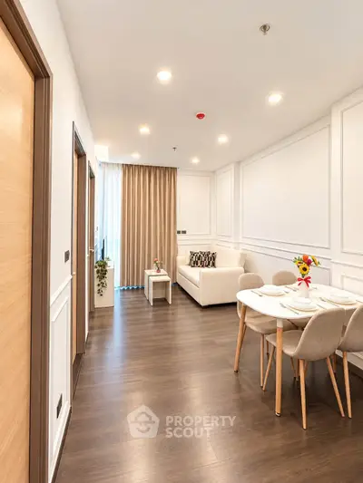 Modern living room with elegant dining area and cozy seating, featuring stylish decor and natural light.
