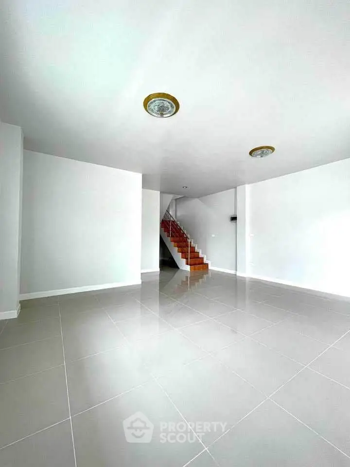 Spacious modern interior with sleek tile flooring and elegant staircase, perfect for stylish living.