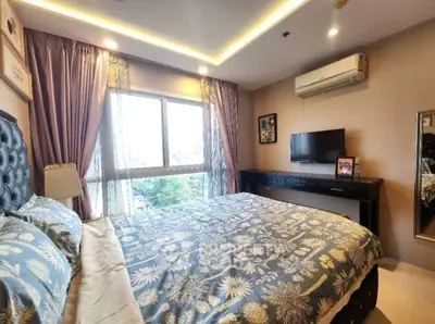 Luxurious bedroom with elegant decor and large window offering natural light and city views.