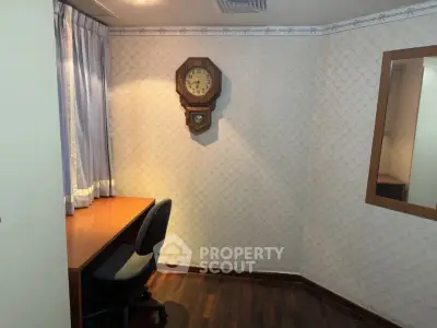 Cozy study room with wooden desk and vintage wall clock, perfect for focused work or study sessions.