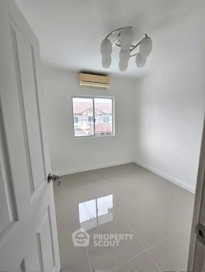 Bright empty room with glossy tiled floor and modern light fixture, ideal for customization.