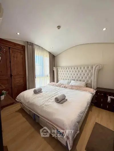 Luxurious bedroom with elegant tufted headboard and wooden accents, perfect for relaxation and comfort.