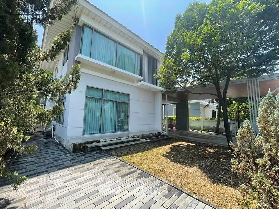 Modern two-story house with large windows and lush greenery, perfect for family living.