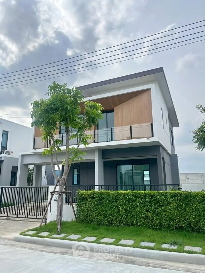 Modern two-story house with sleek design and lush green lawn, perfect for contemporary living.
