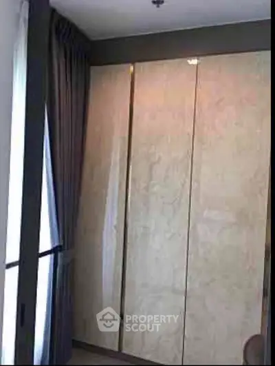 Elegant bedroom with floor-to-ceiling wardrobe and luxurious curtains