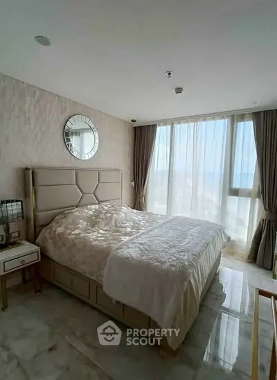 Luxurious bedroom with elegant decor and large window offering natural light.
