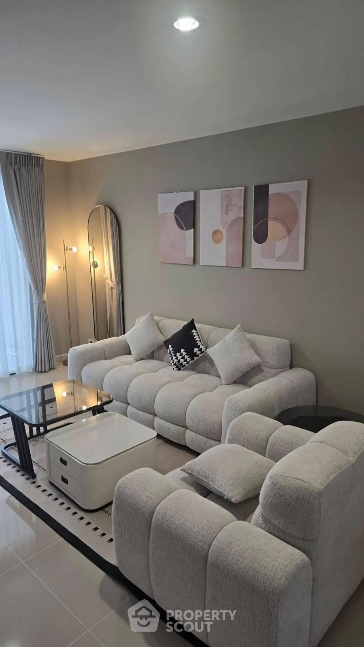 Modern living room with plush sofas, abstract art, and elegant lighting