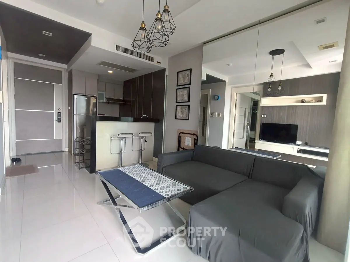 Modern living room with sleek furniture and open kitchen layout in a stylish apartment.