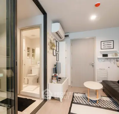 Modern compact living room with adjacent bathroom in stylish apartment