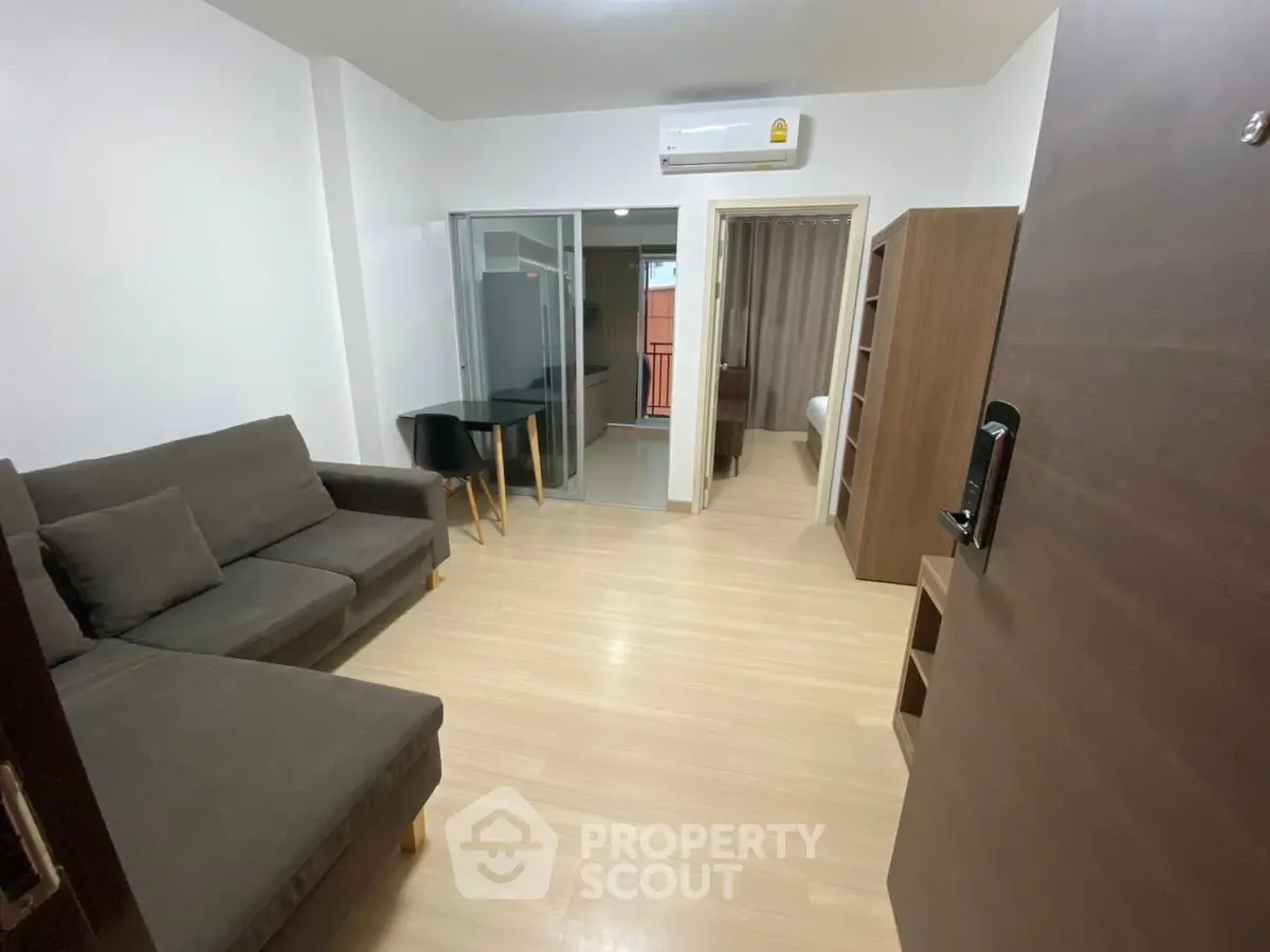 Modern living room with sleek furniture and open layout, featuring a cozy sofa and dining area.