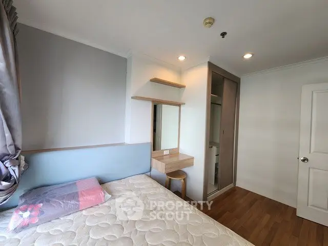 Cozy bedroom with modern design, featuring a comfortable bed, built-in wardrobe, and stylish wooden flooring.