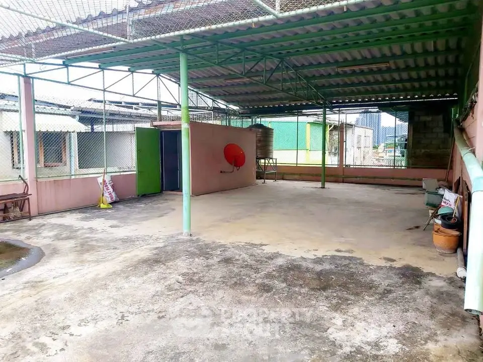 Spacious rooftop area with covered structure and urban views, ideal for versatile outdoor activities.