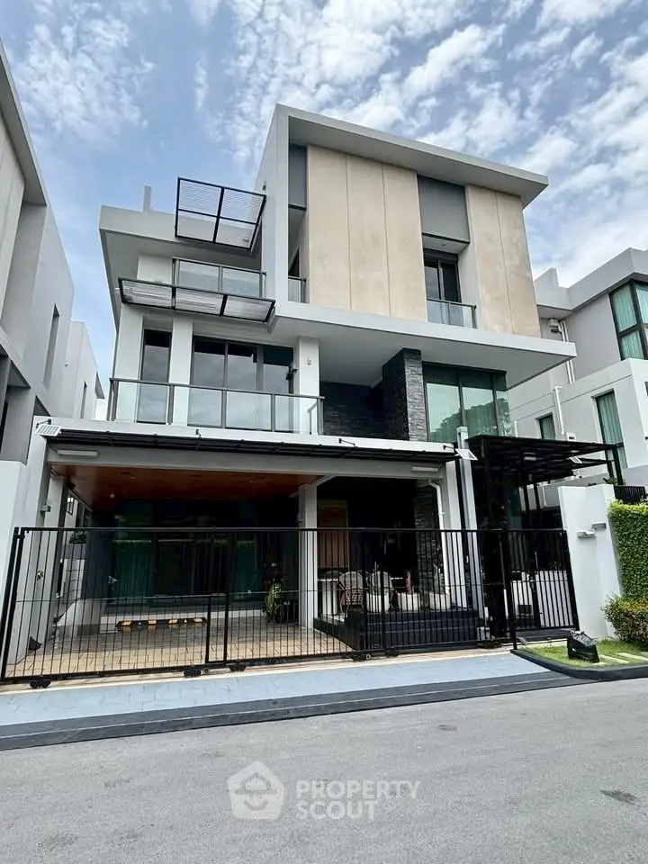 Modern multi-story house with sleek design and spacious balcony in urban setting.