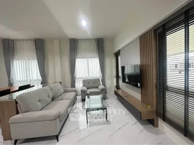 Modern living room with sleek furniture and large windows for natural light.