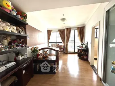 Spacious bedroom with large windows and wooden flooring, featuring cozy decor and ample natural light.