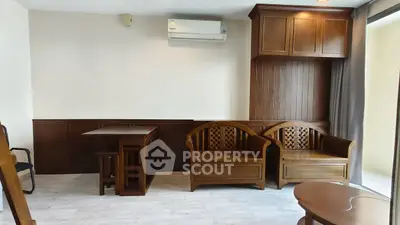 Spacious living room with elegant wooden furniture and modern air conditioning unit.