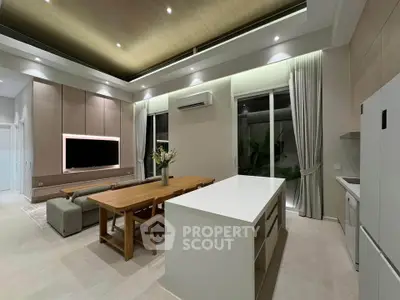 Modern open-layout living room and kitchen with sleek design and ambient lighting