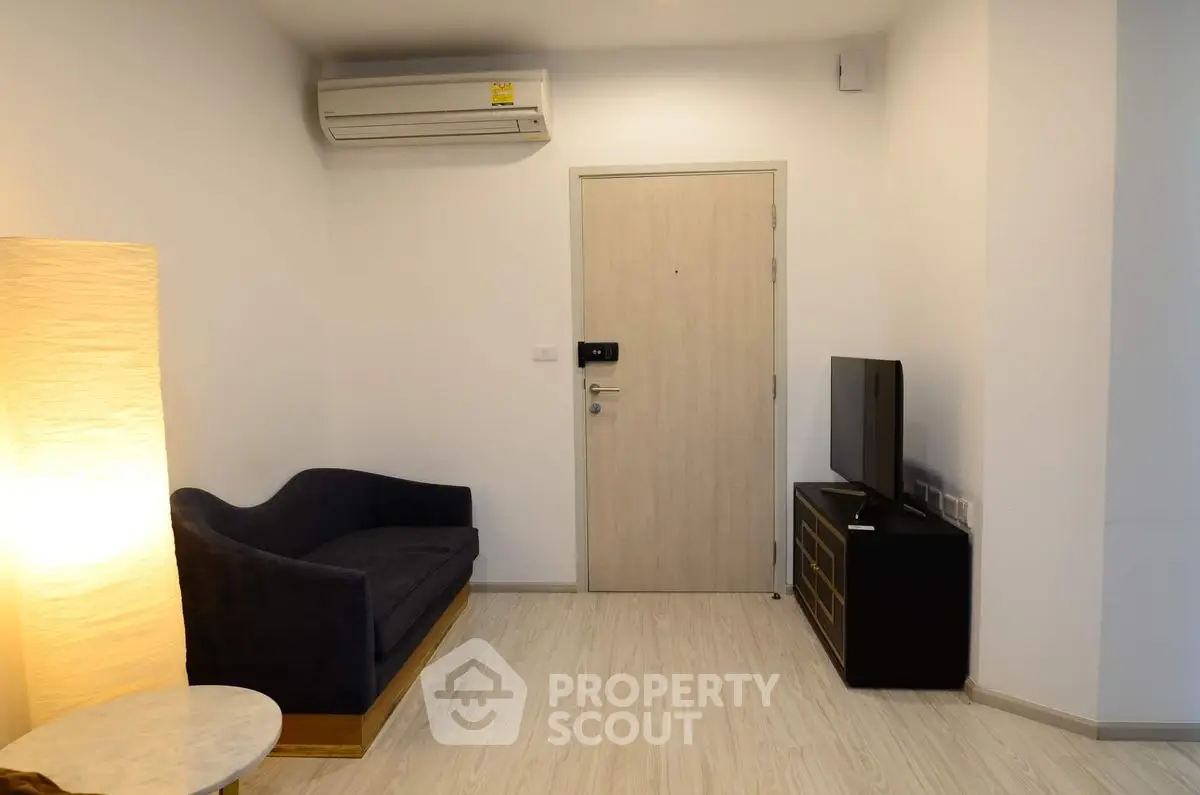 Cozy living room with modern sofa, TV, and air conditioning