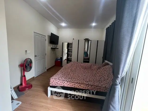 Cozy bedroom with modern decor, featuring a large bed, TV, and ample storage space.