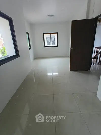 Spacious unfurnished room with large windows and tiled flooring, ideal for customization.
