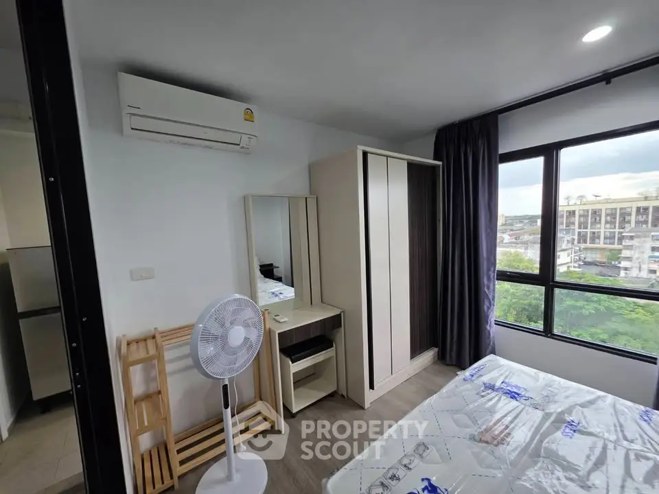 Modern bedroom with large window and air conditioning in urban apartment