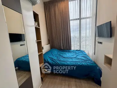 Cozy bedroom with large window and city view, featuring modern decor and wall-mounted TV.