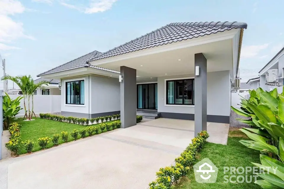 Modern single-story house with manicured garden and spacious driveway