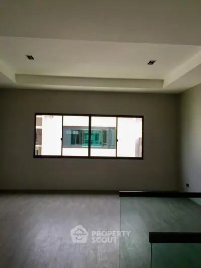Spacious modern living room with large window and sleek flooring