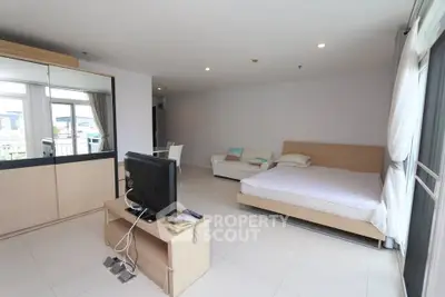 Spacious modern studio apartment with large windows and sleek furnishings