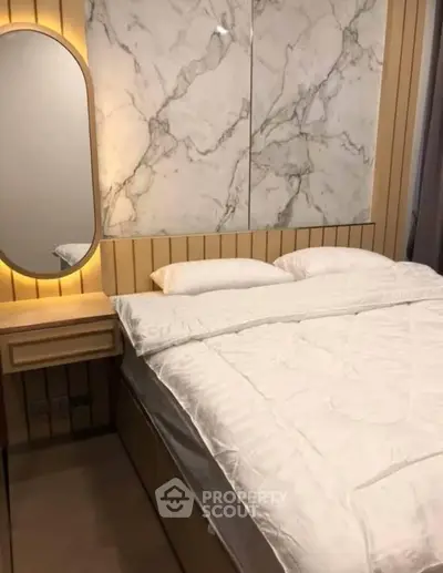 Luxurious bedroom with marble accent wall and modern lighting