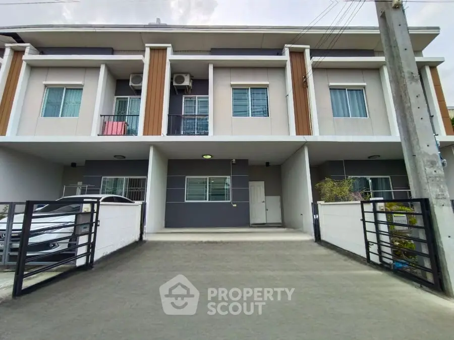 Modern townhouse exterior with driveway and parking space, showcasing sleek design and urban living.