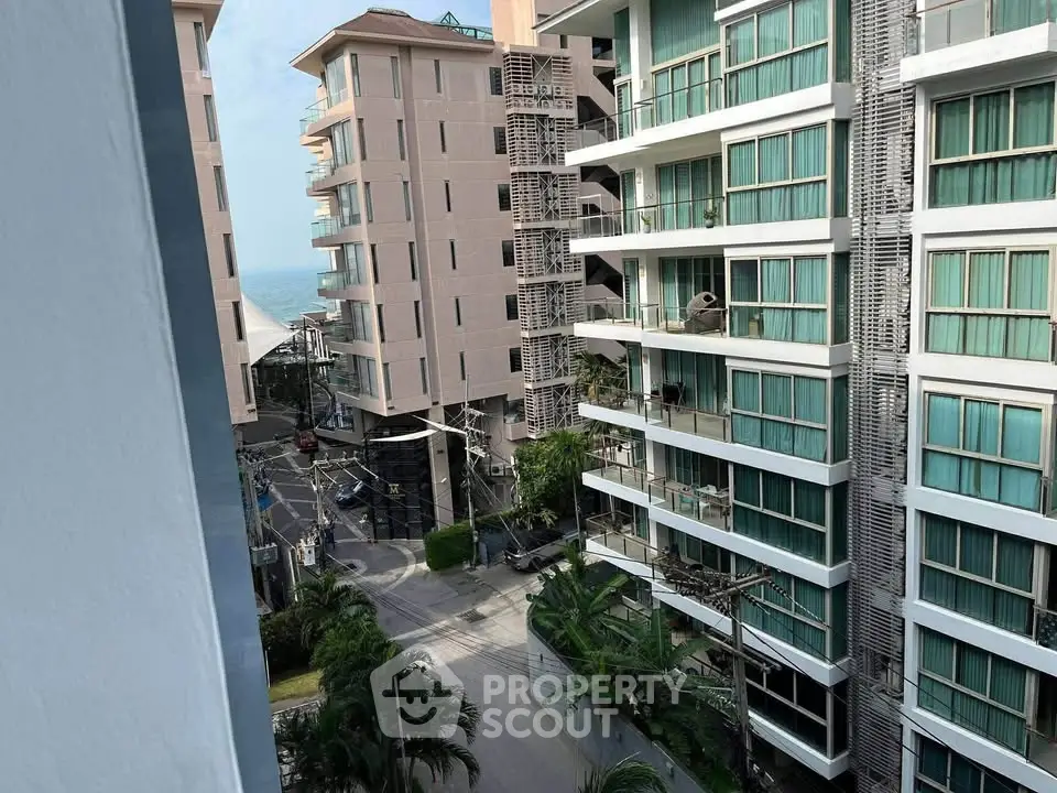 Modern high-rise residential buildings with balconies and ocean view in a vibrant urban setting.