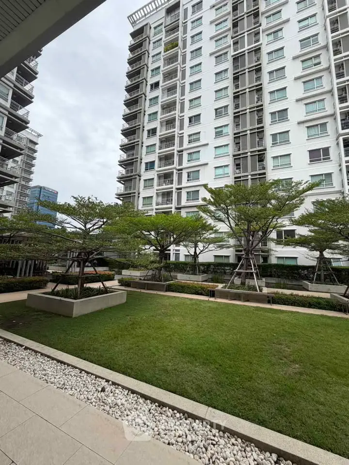 Modern apartment building with landscaped garden and tall trees, offering a serene urban living environment.