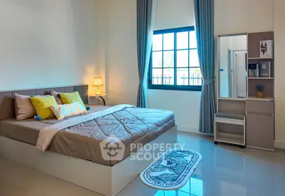 Spacious bedroom with modern decor and large window for natural light.