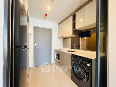 Modern kitchen with sleek appliances and washing machine in compact layout