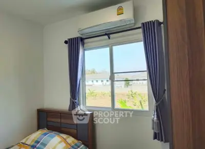 Cozy bedroom with air conditioning and window view, perfect for comfort and relaxation.
