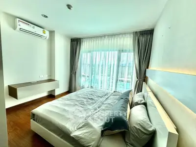 Modern bedroom with large window and stylish decor in a bright apartment