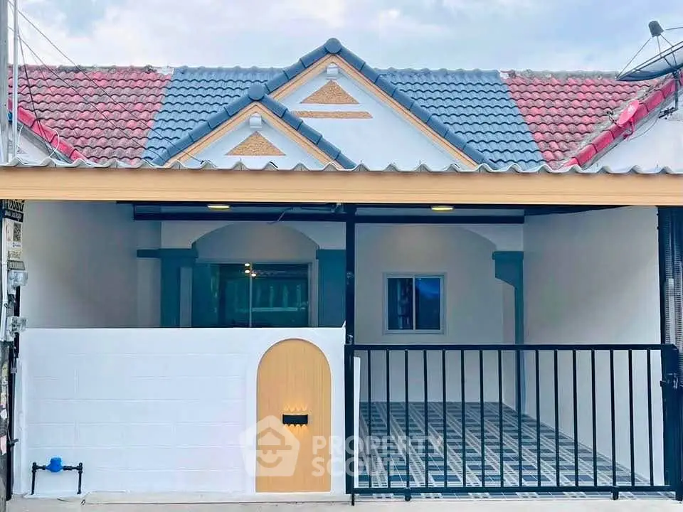 Charming single-story home with unique roof design and spacious front patio.