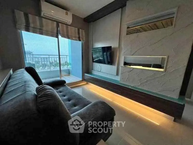 Modern living room with sleek design, large sofa, and balcony view.