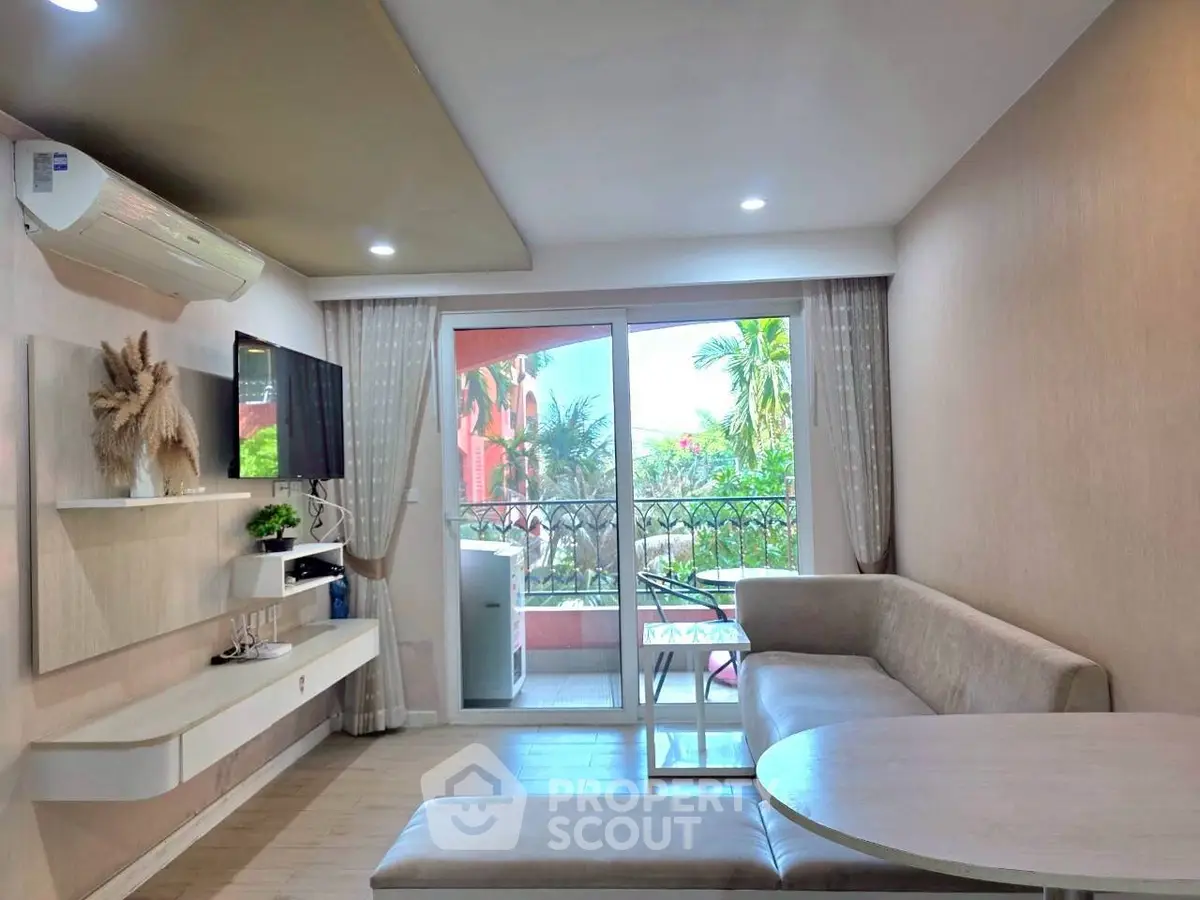 Modern living room with balcony view, stylish decor, and natural light.